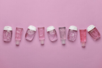 Antiseptic bottles on pink background. Top view