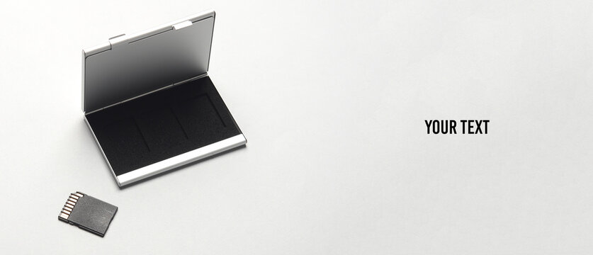 Box holder with SD memory card on a gray background. Copy space