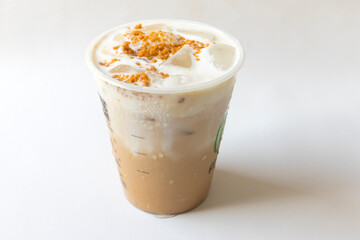 Iced coffee latte with creamy cold foam and caramel crumble. Close up view of Salted caramel milkshake with coffee