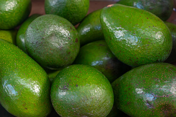 Fresh green avocados with glossy skin in closeup view. Closeup of fresh avocados with natural shine perfect for vegan recipes farm market promotions and superfood branding.
