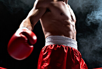 Close-up of a shirtless muscular male boxer in red shorts and a red boxing glove, ready for a fight competition