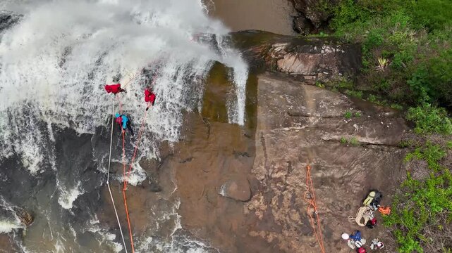 A spinning drone shot of people practising abseiling in a waterfall in Minas Gerais, revealing the background