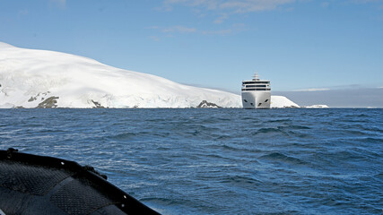 A zodiak boat returns to the expedition cruise ship from its excursion in Antarctica.