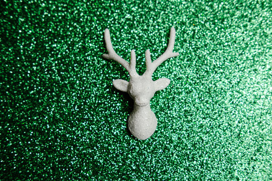 Christmas deer head on a shiny green background. Space for text.