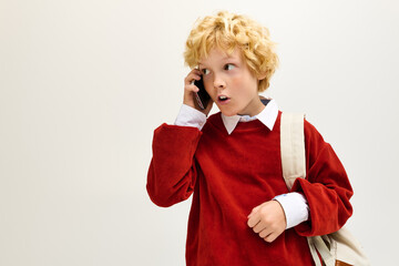 Excited child in stylish outfit engages in animated phone conversation