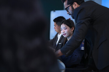 A diverse team of AI strategists, led by a focused man with glasses, develops a new service platform. Two female colleagues analyze data and document the implementation plan in a modern tech hub.