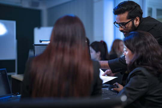 In a 24 7 Security Operations Center, a diverse incident response team works together under pressure, analyzing real-time threat intelligence data to defend against a live cyberattack. - Powered by Adobe