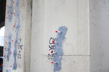 Multiple epoxy injection ports installed for concrete crack repair on building foundation or bridge. Used for structural restoration, sealing, and waterproofing damaged concrete. Selective focus.