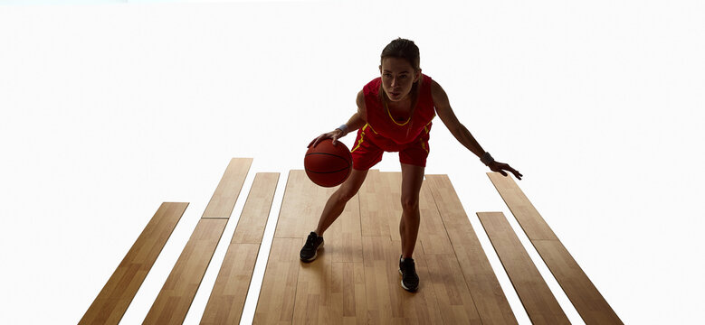 Female basketball player dribbling forward on wooden court with focus. Concept of movement, control, and intensity for sports advertising, training, and digital media use. - Powered by Adobe