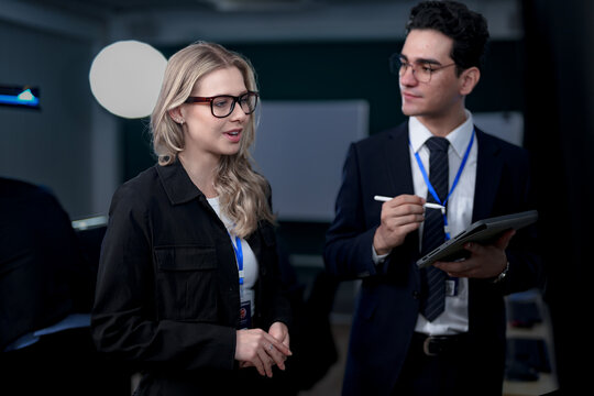 A diverse and dedicated team of professionals works diligently in a bustling, modern tech office at night, collaborating and focusing on their tasks to meet a critical project deadline.