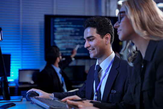 A developer points enthusiastically to the screen, showing his colleague the elegant and efficient code generated by their generative AI coding partner, celebrating a new level of productivity.