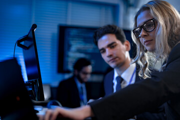 A diverse team of young professionals engages in intensive training, diligently taking notes from a presentation in a modern classroom, focused on their career growth and development.