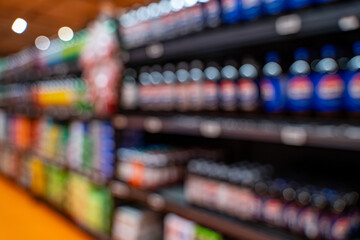 Blurred view of beverage bottles on market shelf.