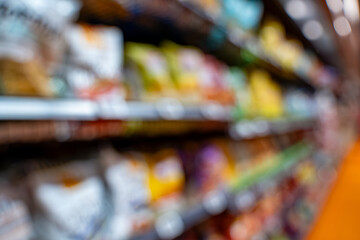 Blurred view of chip bags on market shelf.