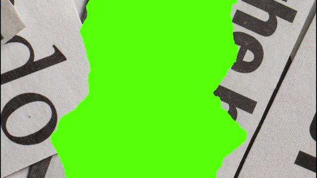 Close up of torn newspaper pieces with black text and green screen background for overlay effect