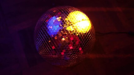 This captivating photo of a disco ball illuminated with colorful lights enhances the dance floor vibes, inviting a celebration of music, movement, and connection.