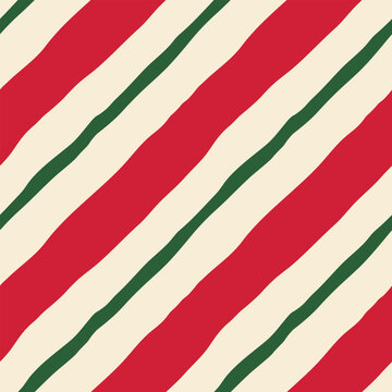 Bright diagonal striped vector seamless pattern. Modern, playful, minimal red and green hand drawn candy stripes repeat design on cream background. Festive geometric tile for fabrics, wrapping, media