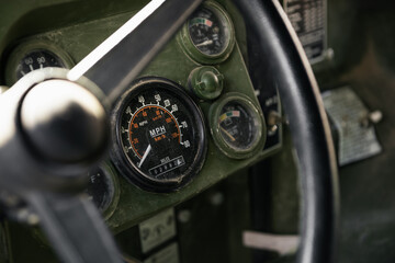 Dashboard of an old military vehicle. POV: behind the wheel of an old truck with analog gauges.
