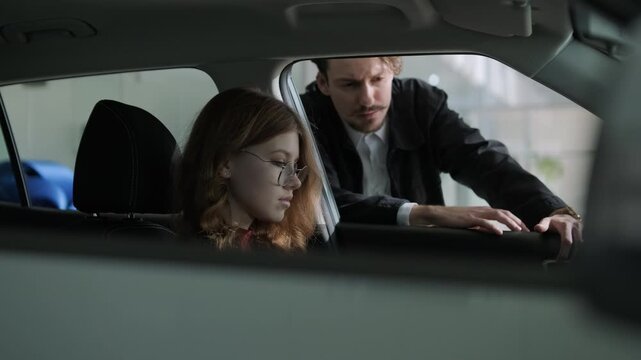 Car buyers exploring vehicles with sales agent assistance at dealership