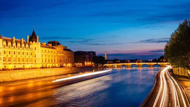 View of Paris by night with the Seine river and the Conciergerie building