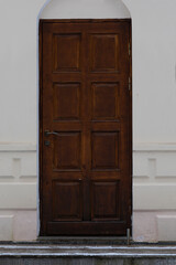 Old rustic entrance, Aged wooden entrance embedded in sunworn plaster exterior surface, Rustic vintage doorway positioned on old stucco wall with weathered white finish
