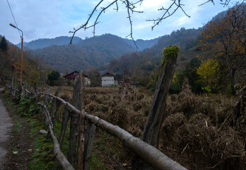 Fototapeta premium Rural autumn landscape with old wooden fence in mountain village