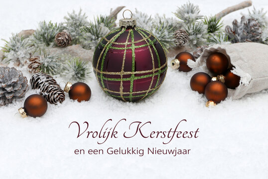 Kerstkaart: Winterlandschap met kerstballen en dennentakken in de sneeuw. De tekst "Vrolijk Kerstfeest en een Gelukkig Nieuwjaar" staat in de sneeuw.