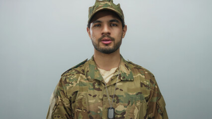 Man in camouflage uniform with dogtags speaks in studio against gray background; pride duty courage...