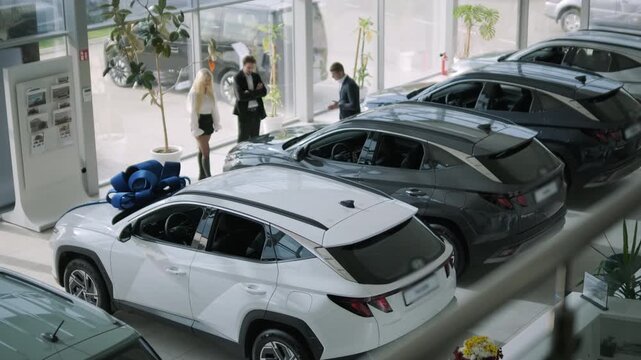Car buyers exploring vehicles with sales agent assistance at dealership
