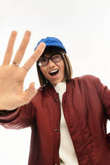 Young woman radiates joy in stylish winter outfit against a bright, minimalist backdrop