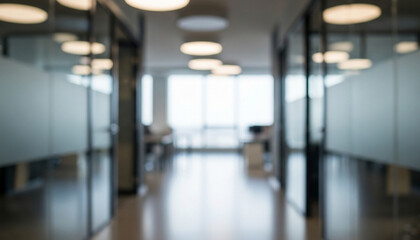 Softly blurred modern office corridor with frosted glass partitions and glowing circular ceiling lights, creating a calm workspace atmosphere with bright daylight filtering through large windows.