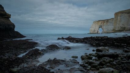 Dramatic Low-Tide View of Étretat’s Natural Rock Arch and Sea Stack on the Alabaster Coast in Normandy, France