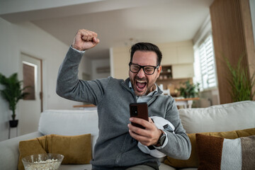 Excited man celebrating sports betting victory on phone