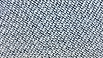 close-up of blue denim fabric texture featuring diagonal twill weave pattern with interwoven indigo...