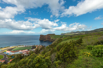 Scenic view of the dramatic coastal cliffs and football field at Fajã de Lopo Vaz on Flores Island, Azores, overlooking the blue Atlantic Ocean