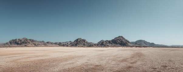 Vast desert landscape with wide sandy ground and rugged mountain ranges under a clear blue sky, idea for travel scenes, nature backgrounds, and panoramic presentation designs