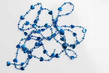 Cadena azul con corazones y esferas para decoración, en plano cenital con fondo blanco