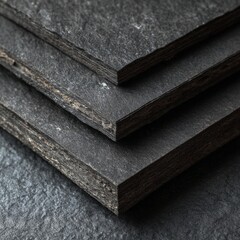 Stacked black slate stone tiles exhibit rich textures and natural layers, perfect for interior design projects, flooring, or decorative elements in contemporary spaces