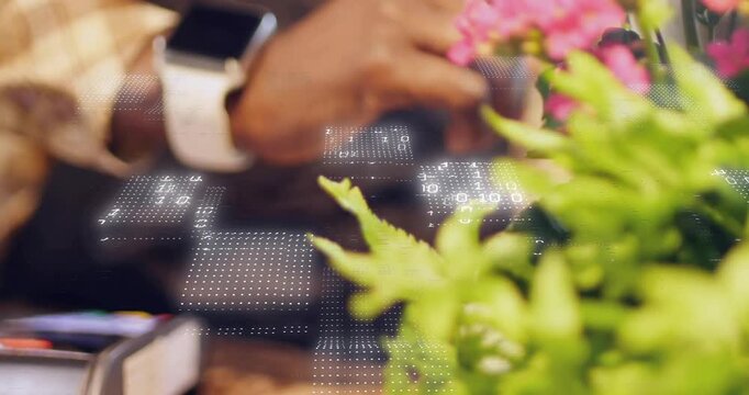 Camera pullback revealing POS, hand tapping terminal then lifting planter to access payment screen