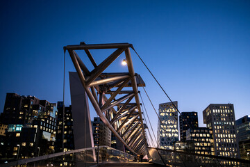 Architecture cityscape at night showing Barcode Oslo skyline behind bridge structure and lights that combine to form a dynamic and recognizable urban scene.