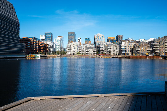 Architecture cityscape of Oslo barcode with water waterfront reflection daytime skyline and buildings forming a bright and open urban view.