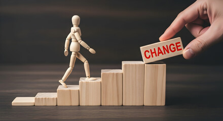 Wooden mannequin climbing steps towards change symbolizing progress and transformation with a hand placing a block labeled "change" for growth and adaptation in business and life