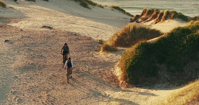 Cycling, drone and horizon with couple outdoor on bike for cardio, exercise or fitness by ocean. Aerial, bicycle and sunset sky with cyclist people by sea in nature for sports, training or workout