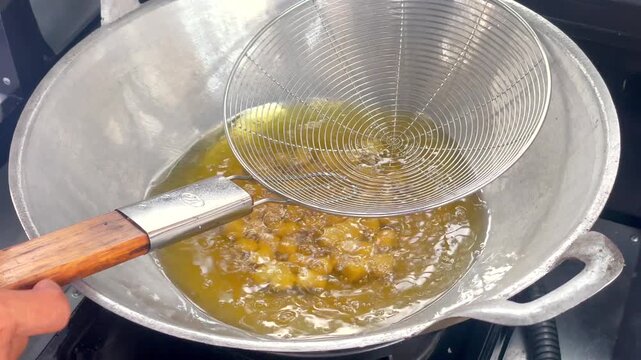 Frying cimol (fried tapioca balls) video in hot oil in a wok.