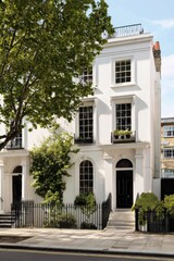 Obraz premium Beautiful white townhouse with greenery in a peaceful neighborhood showcasing classic architecture during a sunny day in an urban setting
