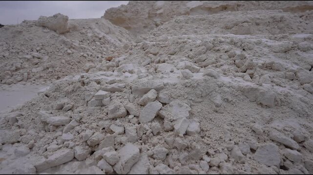 Industrial scene showcasing synthetic gypsum piles, camera pans across textured surfaces, highlighting material details and environmental context