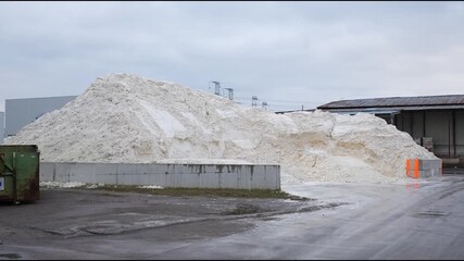 Industrial scene showcasing synthetic gypsum pile with gradual camera zoom, emphasizing texture and scale in a manufacturing environment