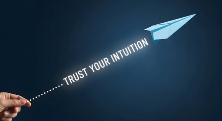 Hand launching a paper airplane with the motivational message trust your intuition against a dark blue background symbolizing guidance and inner wisdom for business success and personal growth