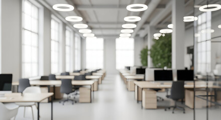 Blurred office interior with desks and computers modern workspace with natural light suitable for backgrounds and design elements