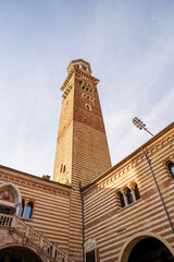 Obraz premium A tall rectangular tower in Verona, Italy The tower is made of red brick Part of the courtyard is visible below